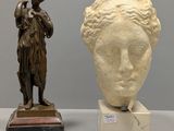 a statue of a woman standing next to a statue of a man