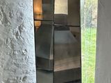 a tall metal object in a room with a window