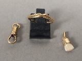 trois bijoux en or, dont une bague, une brosse à dents et une brosse à dents