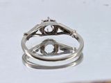 a silver ring with a diamond in it sitting on a table