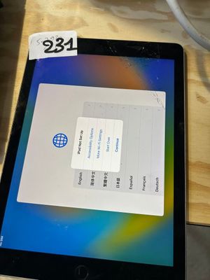 une tablette posée sur une table en bois, à côté d'une tasse de café