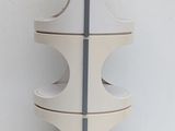 a tall white vase with four sections on top of it
