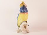 a figurine of a parrot sitting on its hind legs