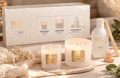 a white box with three candles and a bottle of liquid