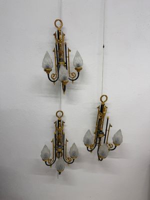 three wall sconces hanging on the wall next to each other
