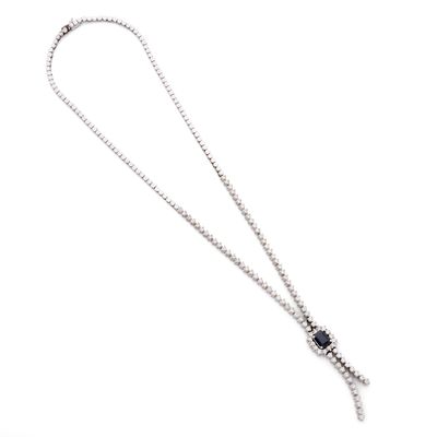 une image représentant un collier en argent orné d'une pierre bleue, sur fond blanc
