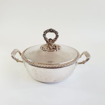 an antique silver plated casserole with handles and handles