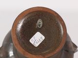 a small brown vase with a tag on it