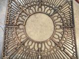 une vieille grille de sol en fonte ornée d'un motif circulaire