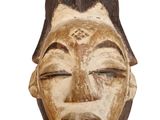 une image montrant un gros plan d'un masque en bois sur fond blanc