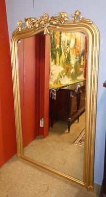un grand miroir doré dans un coin de la pièce