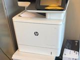 une imprimante posée sur une armoire, à côté d'un réfrigérateur