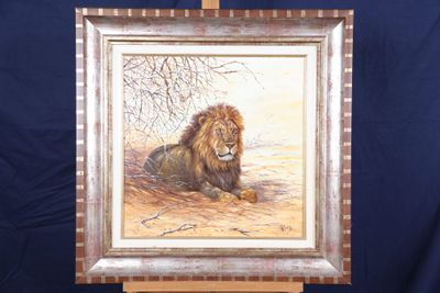 une peinture à l'huile représentant un lion couché sur un chevalet en bois