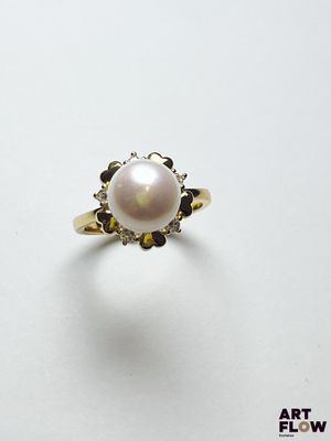 gros plan d'une bague en perles et diamants sur une surface blanche