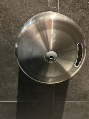 a stainless steel sink in a bathroom with a black tile floor