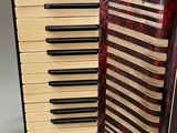 an image of a red and white accordion sitting on top of a table