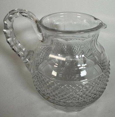 a glass pitcher that is sitting on a table
