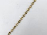 a close up of a gold chain on a white surface