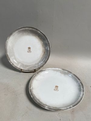 deux assiettes blanches à bordure argentée posées sur une table