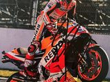 un homme qui roule à moto sur une piste, coiffé d'un casque