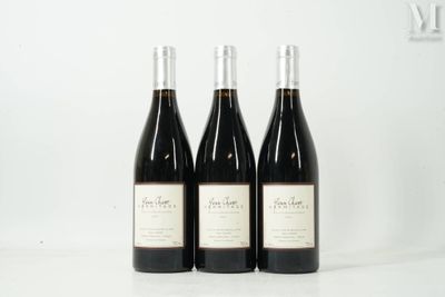 three bottles of wine are lined up on a table