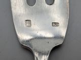 a silver fork with holes in the middle of it