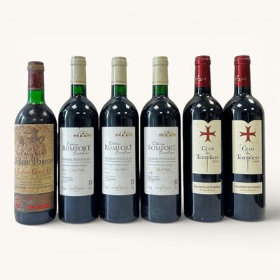 plusieurs bouteilles de vin sont alignées sur une surface blanche
