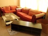 a living room with a couch, coffee table, and a television