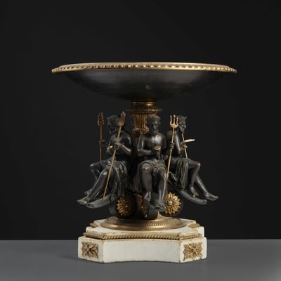 a black and gold vase with four figures sitting on it