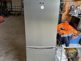 a silver refrigerator in a room with boxes and other items
