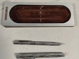 two pens and a pen holder on a table