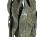 a statue of a woman holding a leaf on top of a table