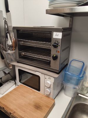 a toaster oven sitting on top of a counter next to a cutting board