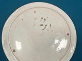 a small white plate with a brown spot on it