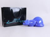 purple cat figurine next to a black shopping bag