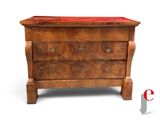 a small chest of drawers with a red velvet on top