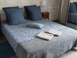 a bed that has a blue comforter and pillows on it