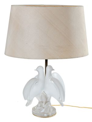 une lampe blanche sur laquelle sont perchés deux oiseaux