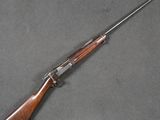 an old rifle with a wooden handle on a gray surface