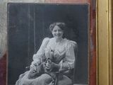 an old picture of a woman sitting in a chair with a cat