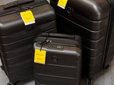 three pieces of luggage sitting on the ground with tags on them