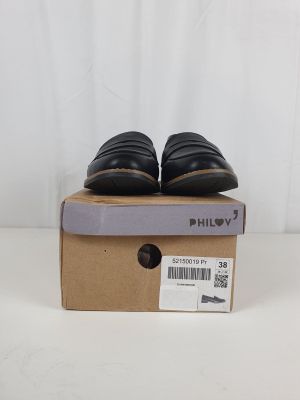 une paire de chaussures noires posée sur une boîte en carton