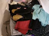a suitcase full of clothes and shoes on a bed