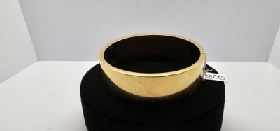 une bague en or posée sur un porte-bague noir