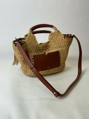 une photo d'un sac en paille muni d'une anse en cuir marron