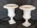 two white vases sitting on a black cloth