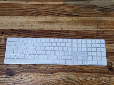 a white keyboard sitting on top of a wooden table