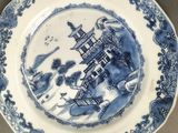 a close up of a blue and white plate with a castle on it