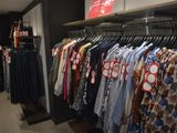 a lot of shirts hanging on a rack in a store