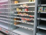 many empty shelves in a store with food on them